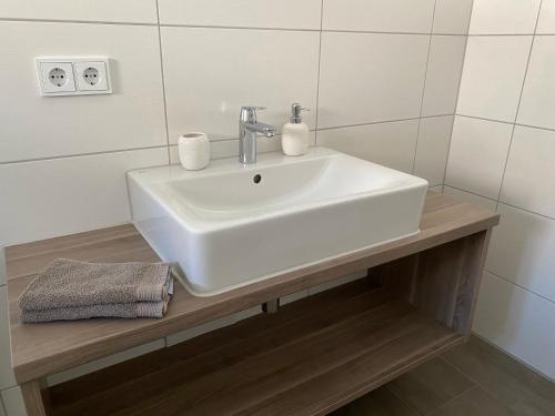 a bathroom with a white sink on a wooden counter at Ferienwohnungen im Färberhaus in Fischen