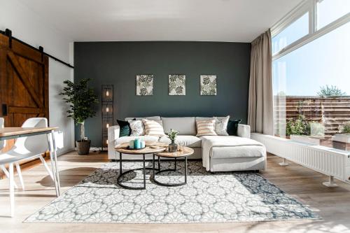 sala de estar con sofá y mesa en Green Happiness With Private Parking, en Zandvoort
