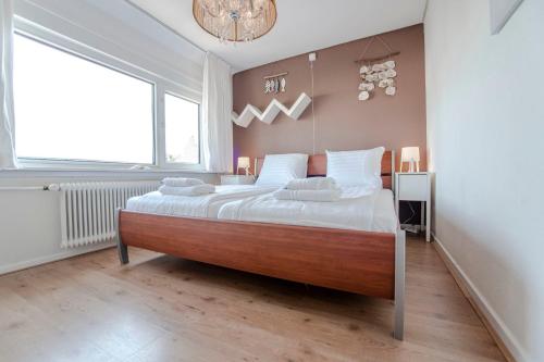 Cette chambre comprend un grand lit et une grande fenêtre. dans l'établissement Sea Star Stay with Private Parking!, à Zandvoort