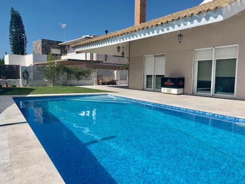 - une piscine en face d'une maison dans l'établissement Casa/Chalet Doñana, à Sanlúcar de Barrameda