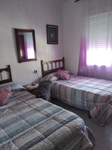 a bedroom with two beds and a window at Casa al-andalus in Granada