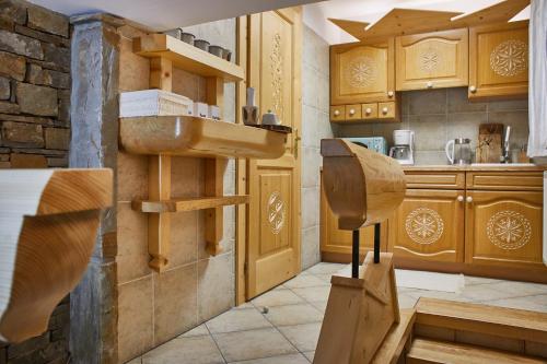 a kitchen with wooden cabinets and a sink at Witkówka WILD Luxury Apartments - Sauna & SPA in Witów