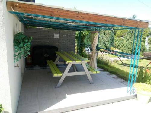 pérgola con banco de picnic en el patio en GM, en Bagnères-de-Bigorre