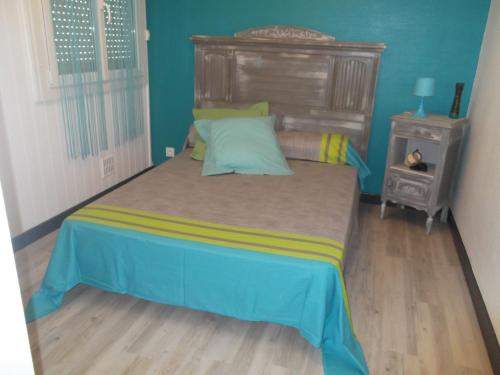 1 dormitorio con 1 cama grande y cabecero de madera en GM en Bagnères-de-Bigorre