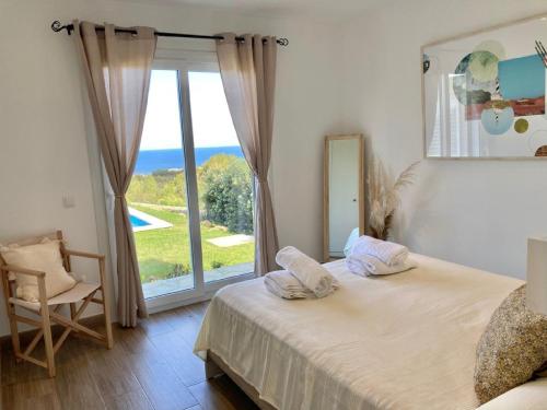 a bedroom with a bed and a large window at Villa Bella in Es Mercadal