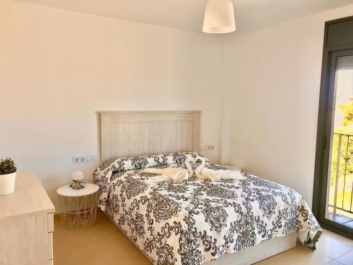 a bedroom with a bed with a black and white comforter at Apartament SomRiu in Deltebre