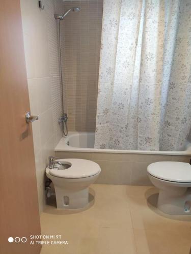 a bathroom with a toilet and a sink and a tub at Apartament SomRiu in Deltebre