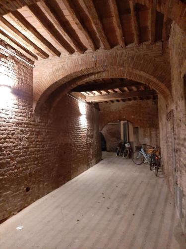 an empty room with two bikes parked in a brick wall at Il Vicolo in Lucca