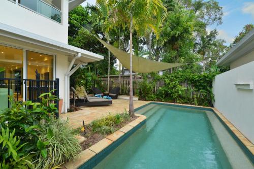 a swimming pool in the backyard of a house at Reef Villa Port Douglas in Port Douglas