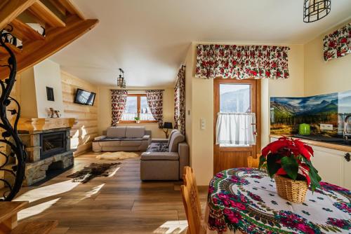 a living room with a table and a fireplace at Noclegi domek in Kościelisko