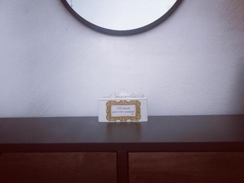 ein Bilderrahmen auf einem Tisch mit einem Spiegel in der Unterkunft Casa Segota in Veli Iž