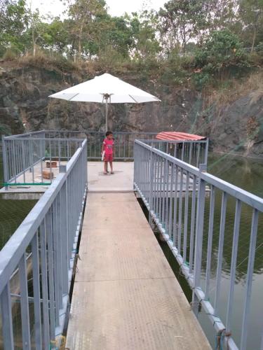 a little girl walking on a bridge with an umbrella at Tranquil Farms in Manimala