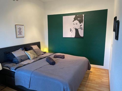 sypialnia z łóżkiem i zieloną ścianą w obiekcie Sky Night Suite w mieście Düren