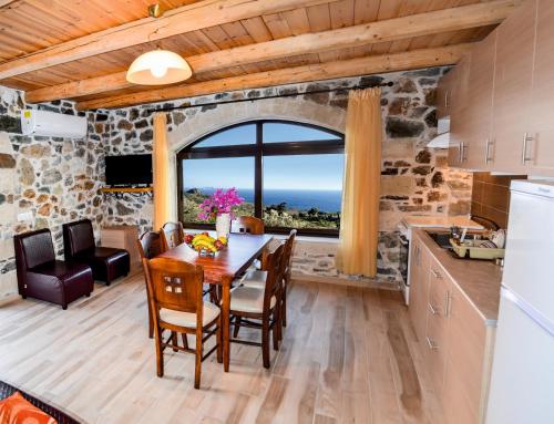 cocina y comedor con mesa y ventana en Villa Irena 2 bedrooms, en Agalianós