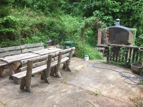 a couple of wooden benches with a hose at Vikendica Lenka in Sijarinska Banja