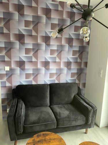 a couch in a living room with a geometric wall at Strandkieker 1 Strandnähe 500m in Ueckermünde