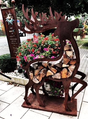 a wooden bench with flowers on it at Hotel Paintner in Germering