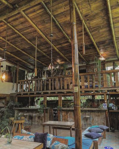 a large room with wooden ceilings and tables and benches at Cinnamon House in Mindo