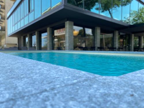 a swimming pool in front of a building at Hotel Costa Verde in Milano Marittima