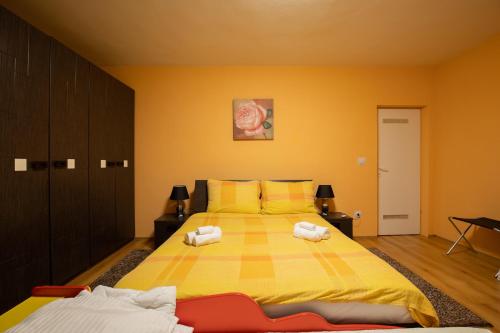 a yellow bedroom with a bed with towels on it at Apartman Vesna in Bjelovar