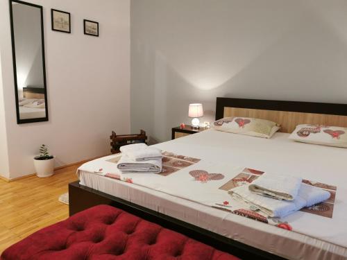 een slaapkamer met een groot bed en een rode poef bij Apartment Vukasevic in Virpazar