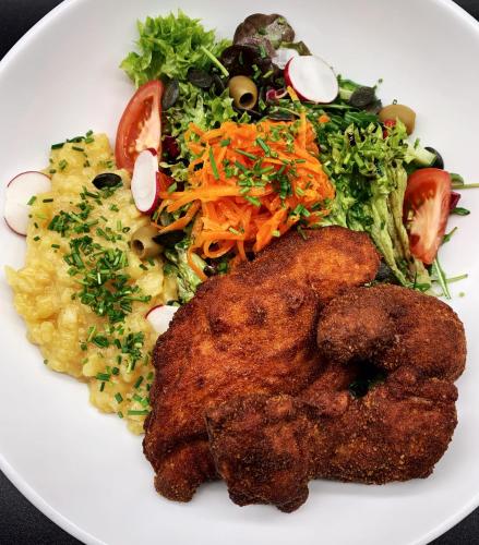 a plate of food with meat and a salad at Hotel Paintner in Germering