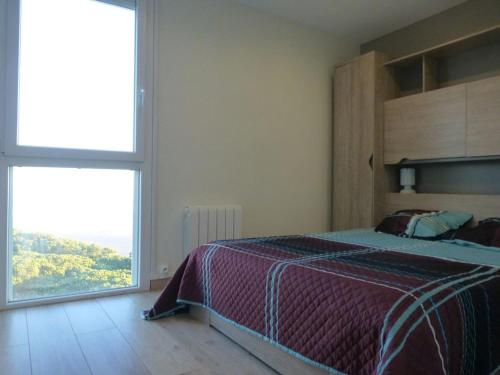une chambre avec un grand lit et une grande fenêtre dans l'établissement Le Belvédère - T2 en front de mer, à Argelès-sur-Mer