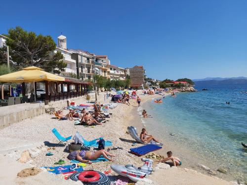 a group of people laying on a beach at Apartmani Apollo - Drasnice in Drasnice