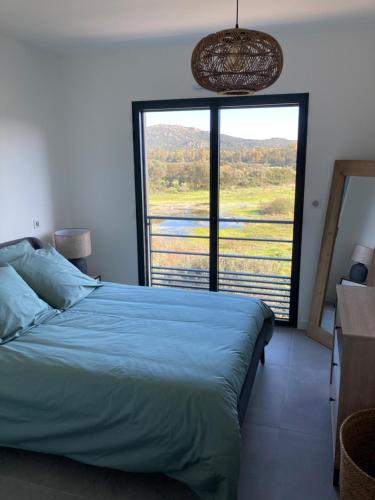 une chambre avec un lit et une grande fenêtre dans l'établissement CASA STANATURA, à Porto-Vecchio