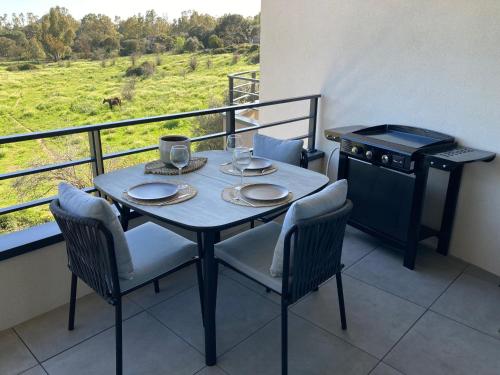 d'une table avec deux chaises et d'une cuisinière sur un balcon. dans l'établissement CASA STANATURA, à Porto-Vecchio