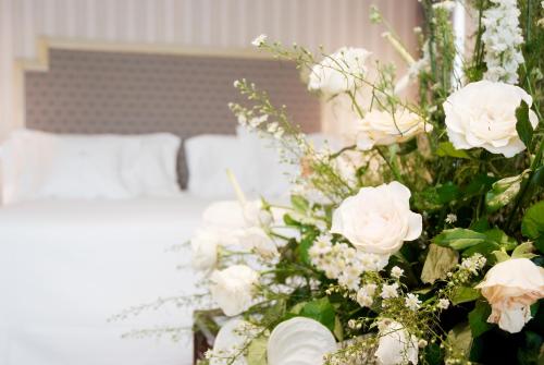 a bouquet of white roses in front of a bed at Gran Hotel La Perla in Pamplona