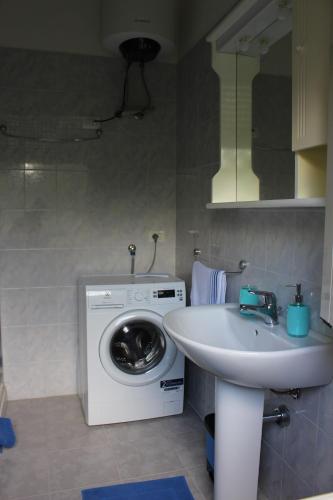 a bathroom with a washing machine and a sink at Smile - appartamento con giardino in Cagliari
