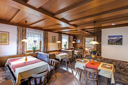 a restaurant with tables and chairs in a room at Naturpension Mühlhof in Neukirchen am Großvenediger