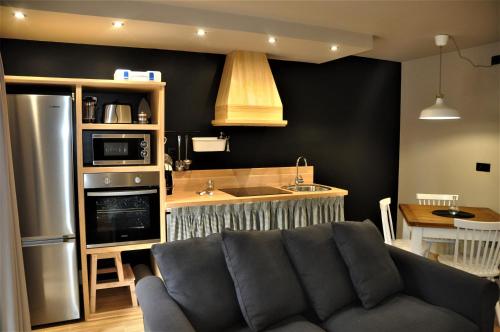 a living room with a couch and a kitchen at Apartamentos Las Agüeras in Linares