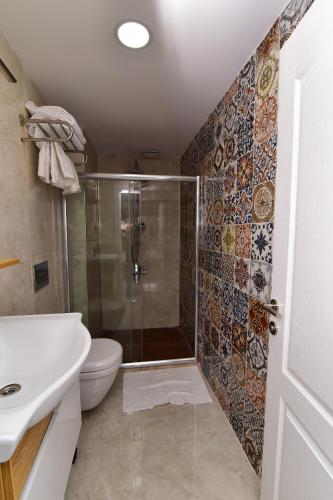 a bathroom with a shower and a toilet and a sink at Little sofia hotel in Istanbul