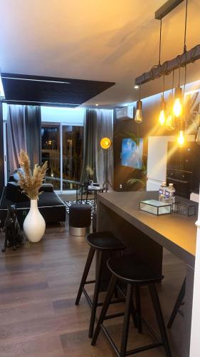 a living room with a table and two stools at Appartement vue port et accès direct mer, centre ville de la Grande Motte prés de Montpellier in La Grande-Motte