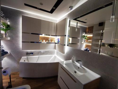 een grote badkamer met een bad en een wastafel bij Apartament SZWEDZKA z duzym 30m Tarasem i garażem podziemnym in Kielce