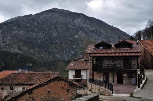 a building with a mountain in the background at Apartamentos Las Agüeras in Linares