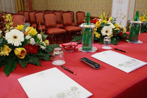 a red table with flowers and bottles on it at Liberty Hotel in Catania