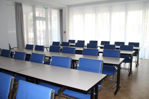 a conference room with tables and blue chairs at Trip Inn Hotel Zum Riesen Hanau in Hanau am Main