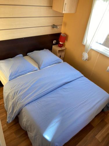 a bedroom with a large bed with white sheets and a window at Lo Soulenquo à Fonteilles sur le GR 65 in Golinhac