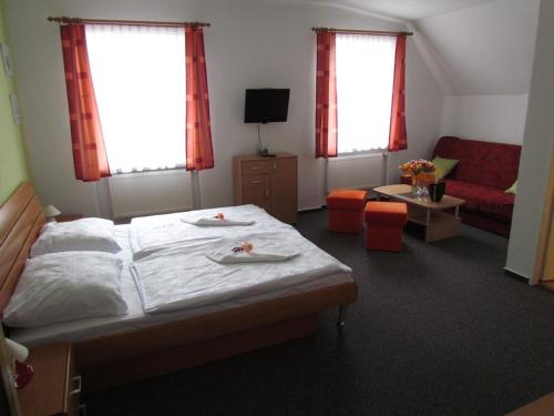 um quarto com uma cama grande e uma sala de estar em Penzion Oregano Třeboň em Třeboň