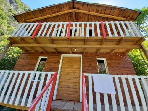 a wooden building with a roof over a door at Park Blini Shala River in Mollʼ e Shoshit