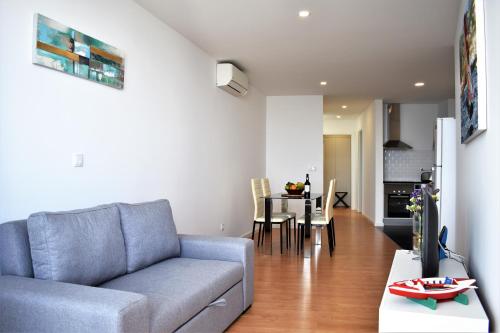 uma sala de estar com um sofá e uma mesa em Sky Blue Apartment em Ponta Delgada