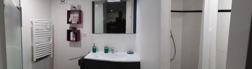 Baño blanco con lavabo y espejo en Suite hauteurs de Vichy en Creuzier-le-Vieux