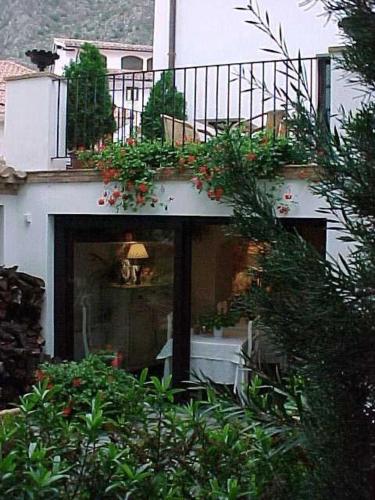 a house with a balcony with plants on it at Casa Rural Las Pedrolas in Arnedillo