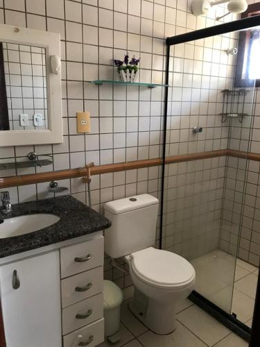 a bathroom with a toilet and a sink and a shower at Casa de praia em condomínio à beira mar in Barra de São Miguel