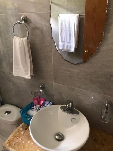 a bathroom with a sink and a mirror and a toilet at Aldea Isla Sagrada in Cozumel