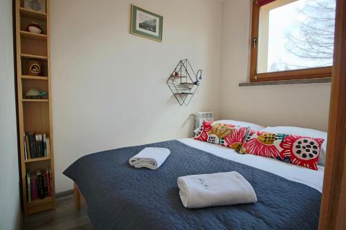 a bedroom with a bed with two towels on it at Apartament BazaTatry Słoneczny II in Zakopane
