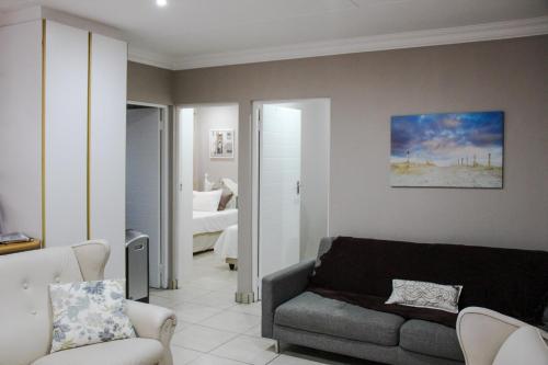 ein Wohnzimmer mit Sofa und ein Schlafzimmer in der Unterkunft Tranquility Self Catering Apartment in Mossel Bay